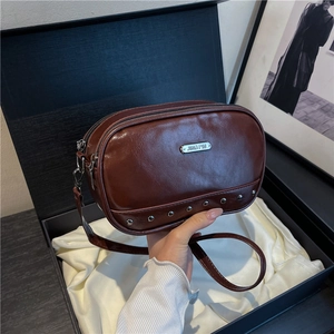Retro dark red crossbody bag with silver rivet studs in a premium gift box display