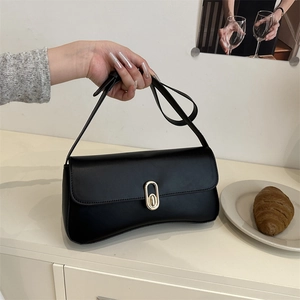 Minimalist black baguette shoulder bag with elegant oval gold buckle and smooth leather finish