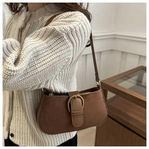 Brown suede underarm bag detail featuring an elegant vintage metal ring buckle design