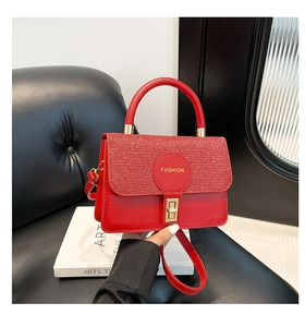 Detail of red glossy leather handbag with sequins and gold fashion turn-lock