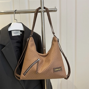 Sac à bandoulière marron tressé avec poche zippée et bandoulière en cuir sur cintre