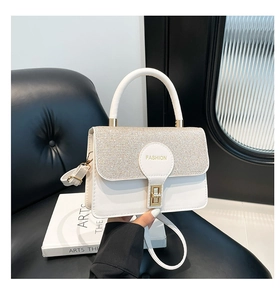 Close-up of white crossbody bag featuring silver sequin flap and fashion logo detail