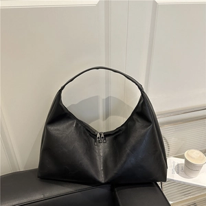 Large black PU leather hobo shoulder bag with dual zipper on a leather sofa