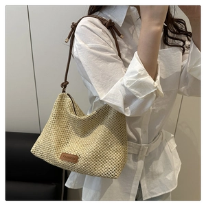 Detail of woven texture on beige hobo tote bag with a brown leather knotted strap