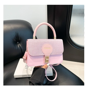 Detail of pink rhinestone flap bag with gold metal twist lock and circular logo