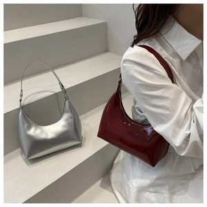 Detail of wine red patent leather and silver metallic hobo bags on geometric steps