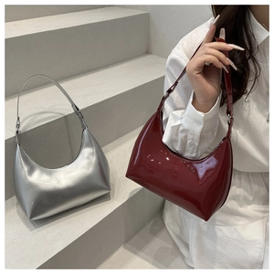Close-up of hobo shoulder bags in metallic silver and glossy burgundy finishes