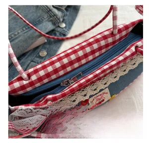 Detailed close-up of the smooth metal zipper on a blue denim canvas handbag