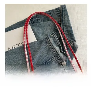 Detail showing white lace trim and red checkered fabric on the stylish tote bag