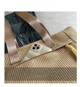 Close-up of a woven tote bag featuring a practical zipper side pocket for smartphones
