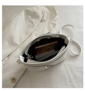 Top view of the spacious black interior of this minimalist cream bucket crossbody bag