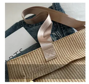 Close-up of reinforced stitching on nylon straps of a woven velvet shoulder tote bag