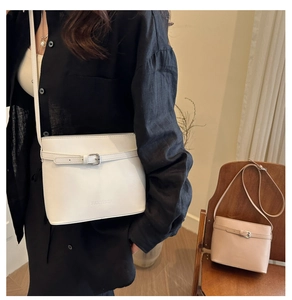 Detail of minimalist bucket bag featuring premium PU leather and branded buckle ornament