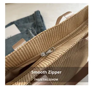 Detail shot of smooth silver metal zipper on beige woven tote bag for secure closure