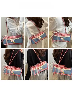 Blue denim barrel bag with red checkered bows and white lace trim shown on model back