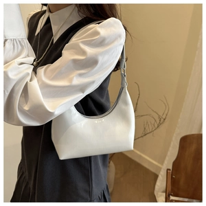 Detail shot of a white glossy hobo bag with sleek shoulder strap and minimalist design