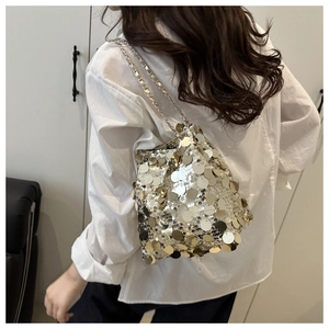Fashionable sequin bucket bag with metal chain shown on white shirt outfit