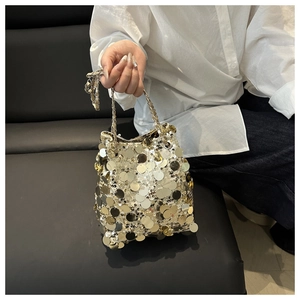 Close-up of gold and silver sequin bucket bag with metal chain handle for parties