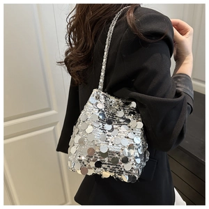 Détail du sac seau à paillettes argentées avec bandoulière en chaîne tressée et texture chic