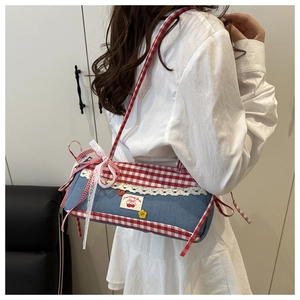 Detail of lace bow and cherry embroidery on blue plaid shoulder bag for women