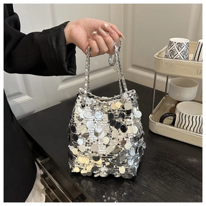 Detail of silver sequin bucket bag featuring metallic round paillettes and chain handle