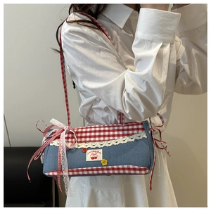 Close-up of sweet cherry embroidery and white lace trim on retro plaid denim handbag