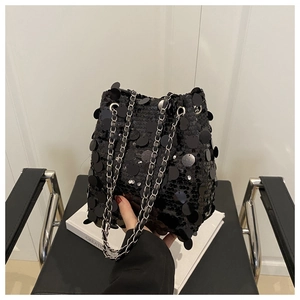 Detailed view of shimmering black sequins and silver chain strap on a stylish bucket bag