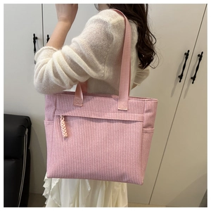 Detail of pink canvas tote bag showing woven texture and durable nylon shoulder straps