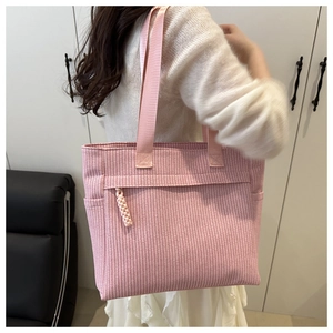 Detailed view of pink woven tote bag showing zippered pocket and durable nylon handle