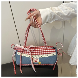 Close-up of lace trim, red plaid bow, and Sweet Cherry Garden label on handbag
