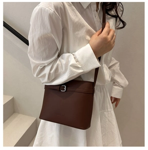 Dettaglio borsa a tracolla vintage in pelle marrone con fibbia e logo in rilievo