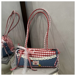 Close-up of denim and red plaid patchwork bag with lace trim and cherry embroidery