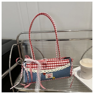 Detail of vintage denim tote bag with red checkered patterns and delicate lace bows