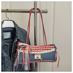 Detail of denim shoulder bag with red plaid panels, lace trim and cherry embroidery patch
