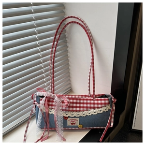 Detailed shot of cherry patch and white lace trim on the checkered denim shoulder bag