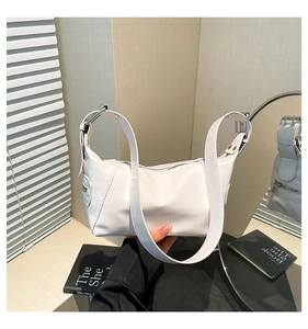Detail of white PU leather hobo bag with large silver metal buckle on wide shoulder strap