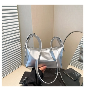 Detailed shot of silver metallic leather handbag with dual handles and logo rivets