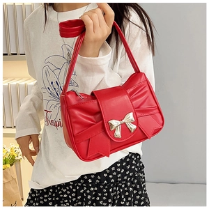 Detail view of a red bow-shaped shoulder bag featuring premium leather and silver buckle
