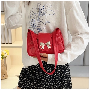 Détail du sac sous le bras plissé rouge avec boucle nœud argentée et cuir PU brillant