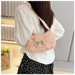 Détail du sac bandoulière rose avec un nœud métallique et d'élégantes coutures latérales