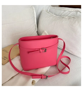 Detailed close-up of hot pink lychee pattern bucket bag on white soft fabric setting