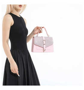 Detail der Glitzerklappe und Metallschnalle an der rosa Kunstlederhandtasche
