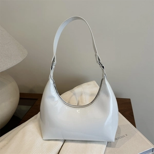 Glossy white hobo bag with minimalist design shown in a cozy home setting