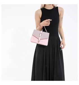 Detail einer rosa Lederhandtasche mit schimmernder Paillettenklappe und goldener Schnalle