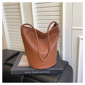 Detailed close-up of brown litchi pattern leather texture on a bucket bag