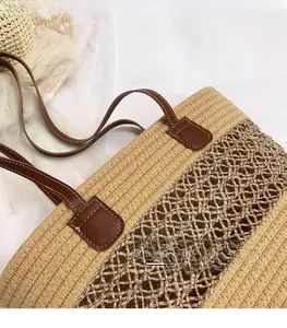 Close-up of handwoven straw tote bag with brown leather handles and mesh weave details