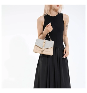 Détail du sac à main en cuir beige et paillettes argentées porté par un mannequin en noir