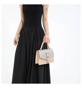 Details der beigen Handtasche mit silberner Glitzerklappe und goldener Vintage-Schnalle