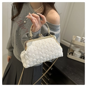 Detailaufnahme der weißen Spitzen-Abendtasche mit Perlengriff und goldener Metallkette