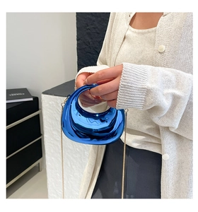 Macro shot of electric blue metallic mirror bag with a fine gold chain strap details